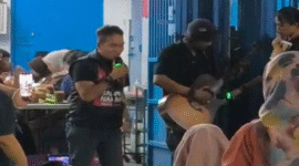 Udhin Leaders (kiri) saat ikut bernyanyi dengan seorang pengamen (kanan) yang menyanyikan lagu Salimu Naraka