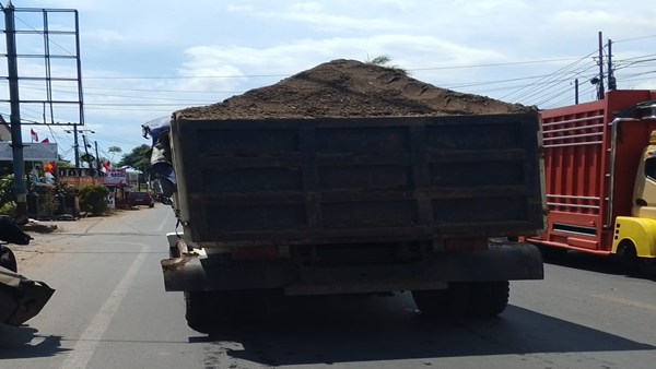 Dump truk pengankut material bak terbuka di jalan poros gowa