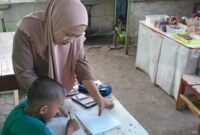 Muh Abil Faiz, murid kelas 1 SD Negeri Borong Makassar, tampak serius mengerjakan PR di kantin sekolah bersama ibunya, Bu Ariati.