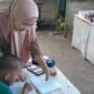 Muh Abil Faiz, murid kelas 1 SD Negeri Borong Makassar, tampak serius mengerjakan PR di kantin sekolah bersama ibunya, Bu Ariati.