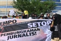 Aksi damai. Para jurnalis membentangkan spanduk dan menyuarakan penolakan terhadap kriminalisasi media.