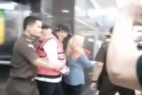 Mantan Pj Gubernur Sulsel, Bahtiar Baharuddin, digiring penyidik Kejati Sulsel dengan mengenakan rompi tahanan merah dan topi usai ditetapkan sebagai tersangka dalam kasus dugaan korupsi pengadaan bibit nanas.