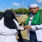 Penyerahan piala Juara I kepada salah satu peserta dalam rangkaian kegiatan yang berlangsung di lapangan terbuka.