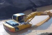 Excavator sedang mengeruk atau memindahkan material dari dasar genangan Milik H Ruppa