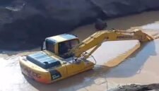 Excavator sedang mengeruk atau memindahkan material dari dasar genangan Milik H Ruppa