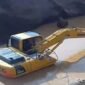 Excavator sedang mengeruk atau memindahkan material dari dasar genangan Milik H Ruppa